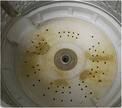Sticky detergent and fabric softener residue coating washing machine drum before cleaning